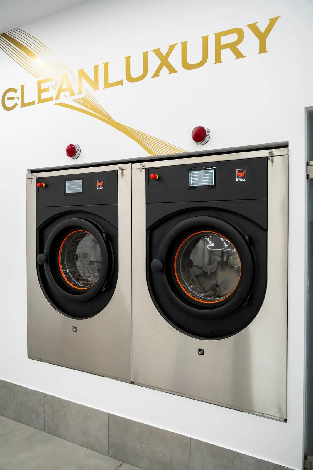 Insegna dorata Clean Luxury sopra due lavatrici professionali nell'area di lavaggio di Firenze